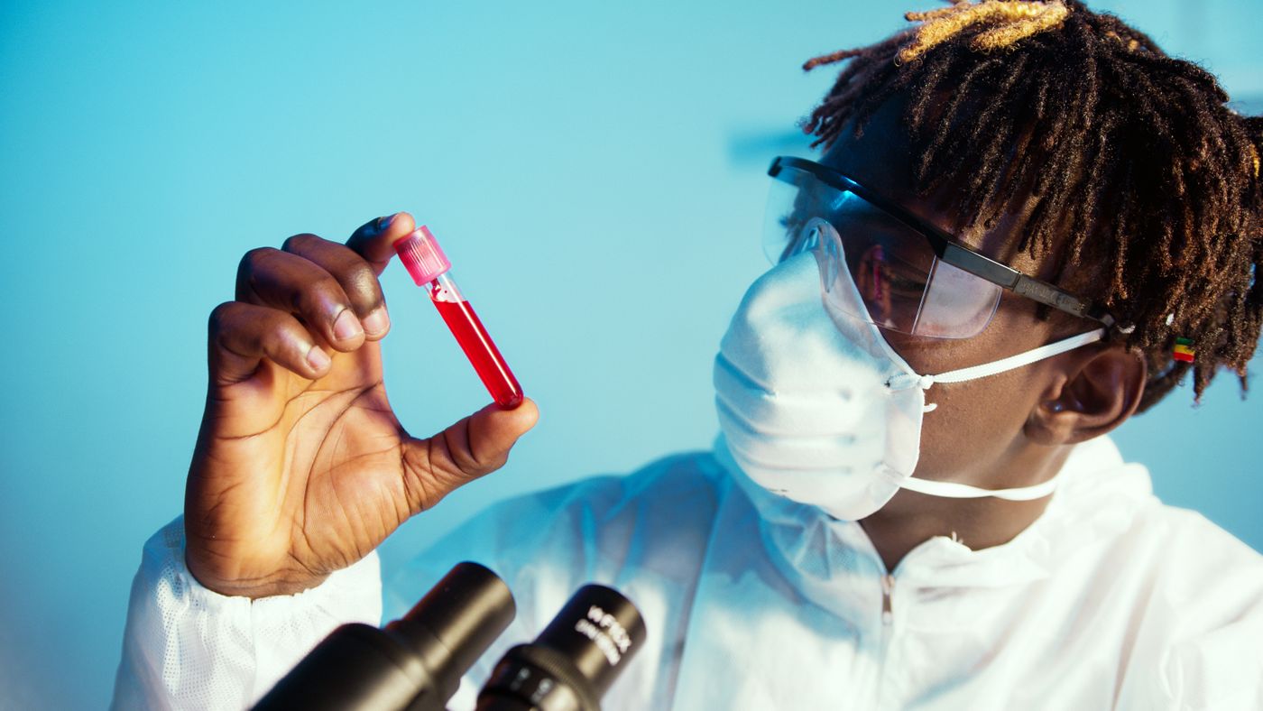 Un technicien de laboratoire examine un tube de prélèvement sanguin.